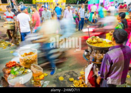 Verschwommenes Bild von Howrah, Westbengalen, Indien. Hinduistisch-bengalische Anhänger genießen Chotpoti und Velpuri, indische bengalische Speise am Straßenrand. Langsamer Verschluss Stockfoto