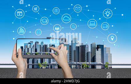 Smart City auf einem digitalen Touchscreen-Mobiltelefon mit einem anderen Symbol. Stadt mit Infografik-Elementen. Intelligentes Stadtkonzept. Stockfoto