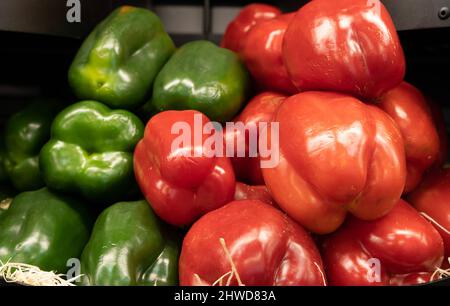 Primeur Obst und Gemüse. Detail von roten Paprika und grünen Paprika bei einem Gemüsehändler Stockfoto
