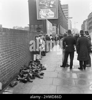 Skinheads treffen sich in der Farringdon Road, London. Zwanzig bis dreißig Jugendliche wurden entlang der Farringdon Road verfolgt, nachdem sie einen verbebten Zug und einen angeblichen Angriff auf einen Mann verübt hatten. Die Häupter wurden angehalten und mussten ihre Stiefel ausziehen, während die Polizei sie an einer Wand anstellte und sie durchsuchte. Das Bild zeigt: Jugendliche, deren Schuhe und Schüsse entfernt wurden, stehen an der Wand, während die Polizei Ermittlungen anstellt. 4.. April 1970. Stockfoto