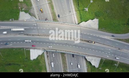 Erhöhte Schnellstraße. Clip. Draufsicht auf Kurven und Linien der Stadtautobahn. Die Kurve der Hängebrücke. Landschaftlich reizvolle Straße im Hintergrund. Stockfoto