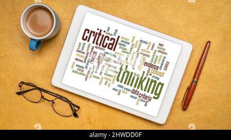 Kritisch denkende Wortwolke auf einem digitalen Tablet, flach lag mit einer Tasse Kaffee Stockfoto