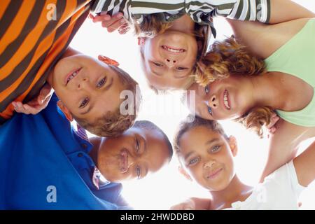 Die Zukunft gehört ihnen. Gemischte Renngruppe von Kindern, die im Kreis stehen und auf die Kamera blicken. Stockfoto