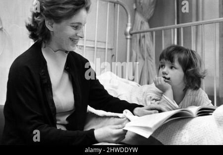 Das Royal Hospital for Sick Children, Yorkhill, Glasgow. Mrs Elizabeth Hunter schaut mit ihrer vierjährigen Tochter Lorna durch ein Bilderbuch. Mütter können ihre Kinder jederzeit im Krankenhaus besuchen. 7. Mai 1969. Stockfoto