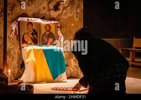 Porto, Portugal. 04. März 2022. Ein Mitglied der ukrainischen Gemeinde, Mitglied des Chores der Ukrainisch-Orthodoxen Pfarrei St. Pantaleon, zündet während der Mahnwache eine Kerze an. In der Cedofeita-Kirche in Porto fand eine gemeinsame Mahnwache für das ukrainische Volk statt, die von der Ukrainisch-Orthodoxen Pfarrei St. Pantaleon, der Ukrainisch-Griechisch-Katholischen Kirche und der Katholischen Pfarrei Cedofeita organisiert wurde. (Foto von Teresa Nunes/SOPA Images/Sipa USA) Quelle: SIPA USA/Alamy Live News Stockfoto