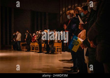 Porto, Portugal. 04. März 2022. Die Menschen sahen während der Mahnwache beten in der Kirche. In der Cedofeita-Kirche in Porto fand eine gemeinsame Mahnwache für das ukrainische Volk statt, die von der Ukrainisch-Orthodoxen Pfarrei St. Pantaleon, der Ukrainisch-Griechisch-Katholischen Kirche und der Katholischen Pfarrei Cedofeita organisiert wurde. (Foto von Teresa Nunes/SOPA Images/Sipa USA) Quelle: SIPA USA/Alamy Live News Stockfoto