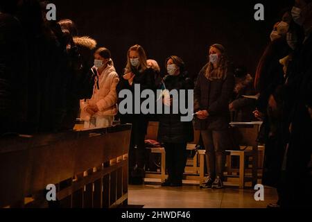 Porto, Portugal. 04. März 2022. Die Menschen sahen während der Mahnwache beten in der Kirche. In der Cedofeita-Kirche in Porto fand eine gemeinsame Mahnwache für das ukrainische Volk statt, die von der Ukrainisch-Orthodoxen Pfarrei St. Pantaleon, der Ukrainisch-Griechisch-Katholischen Kirche und der Katholischen Pfarrei Cedofeita organisiert wurde. (Foto von Teresa Nunes/SOPA Images/Sipa USA) Quelle: SIPA USA/Alamy Live News Stockfoto