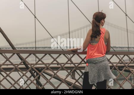 Praktizierende Frau Joggen auf der Brooklyn Bridge Stockfoto