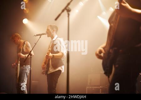 Sie bewegen sich mit ihrem musikalischen Klang. Ausgeschnittene Aufnahme von Musikdarstellern auf der Bühne. Stockfoto