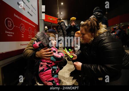 Warschau, Polen. 5. März 2022. Ein Kind und einige ukrainische Flüchtlinge reagieren auf den Warschauer Westbusbahnhof (Dworzec Autobusowy Warszawa Zachodnia), als sie nach der russischen Invasion in die Ukraine, die Millionen Ukrainer zur Flucht gezwungen hat, auf die Überführung in andere Städte oder Länder warten. Polen, Litauen, die Slowakei und andere Länder bieten ihren Flüchtlingen aus der Ukraine ihre Hilfe an, während einige Länder wie die USA oder das Vereinigte Königreich Sanktionen gegen Russland verhängt haben. (Bild: © Daniel Ceng Shou-Yi/ZUMA Press Wire) Stockfoto