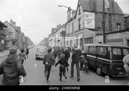 Der Komiker Ken Dodd eröffnet Wohnungen in der Ducie Street und der Beaconsfield Street, Toxteth, Liverpool. Zwei Häuser, eines in jeder Straße, wurden unter einem Team von Schutzhütten- und Planungsexperten zu Wohnungen umgebaut. Ken wird von Fans gejagt, als er von der Ducie Street zur Beaconsfield Street ging, um sich die neuen Häuser anzusehen, die in Wohnungen umgewandelt wurden. 7.. April 1970. Stockfoto