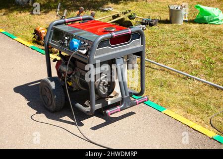 Benzingenerator. Ausrüstung für die Stromversorgung. Mittel zur Stromerzeugung. Ausrüstung auf der Straße. Stockfoto