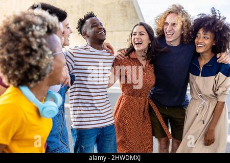Multiethnische junge Freunde, die im Freien gemeinsam lachen Stockfoto