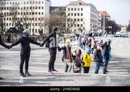 München, Bayern, Deutschland. 5. März 2022. Im Rahmen von fast täglichen Demonstrationen gegen den Krieg in der Ukraine organisierten die Münchner eine Menschenkette, die sich zwischen den russischen und den ukrainischen Konsulaten spannte. (Bild: © Sachelle Babbar/ZUMA Press Wire) Stockfoto