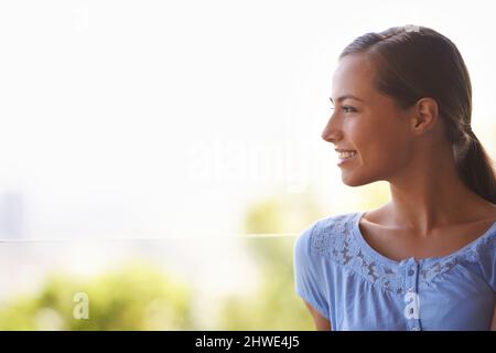 Sie liebt die kühle Brise auf ihrem Gesicht. Profilaufnahme einer wunderschönen jungen Frau. Stockfoto