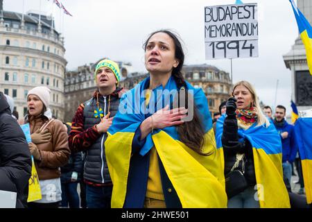 London, Großbritannien. 05. März 2022. Demonstranten singen die ukrainische Nationalhymne während eines Protestes gegen die russische Invasion in der Ukraine auf dem Trafalgar Square. Kredit: SOPA Images Limited/Alamy Live Nachrichten Stockfoto