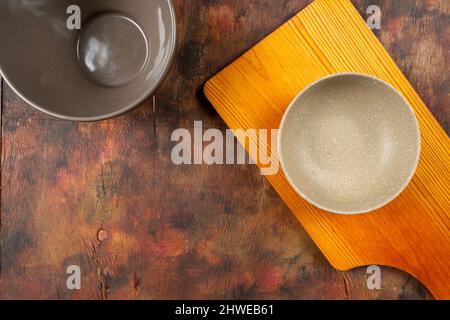 Verschiedene Arten von leeren Schüsseln auf einem alten Holzhintergrund in Brauntönen. Konzept von Knappheit und Mangel an Nahrungsmittelversorgung Stockfoto