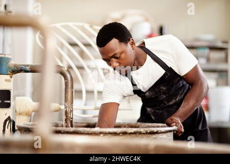 Hes ein Tausendsassa in seiner Bäckerei. Ausgeschnittene Aufnahme eines jungen Mannes, der in einer Bäckerei arbeitet. Stockfoto