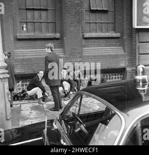 Skinheads treffen sich in der Farringdon Road, London. Zwanzig bis dreißig Jugendliche wurden entlang der Farringdon Road verfolgt, nachdem sie einen verbebten Zug und einen angeblichen Angriff auf einen Mann verübt hatten. Die Häupter wurden angehalten und mussten ihre Stiefel ausziehen, während die Polizei sie an einer Wand anstellte und sie durchsuchte. Bild zeigt: Jugendliche sammeln ihre Stiefel nach polizeilichen Ermittlungen. 4.. April 1970. Stockfoto