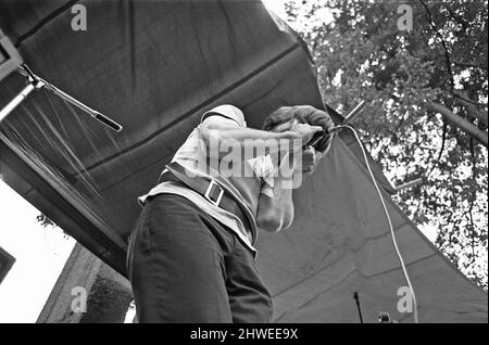 Cannon Hill Park New People Concert. 31.. August 1969. Sie kamen ruhig in den Park. Die neue Generation, die sich der neuen Regel aneigne, sah ungewöhnlich aus, war auf einer anderen Pilgerreise in ihre eigene Welt voller lautem Lärm und wenig Unterhaltung. Dieses Mal war der Blues bei einem Konzert im Cannon Hill Park in Birmingham frei, aber er hätte überall sein können. Die Gesichter sind nicht wichtig: Es ist der Look, der zählt. Die Haare stehen am Ende oder hängen in schlaffen Gewirr, die meist eingeschalteten Kleidungsstücke werden aus zweiter Hand gekauft, verblasste Jeans werden nicht wegen Löchern, sondern wegen Mode geflickt. Es ist alles ein im Stockfoto