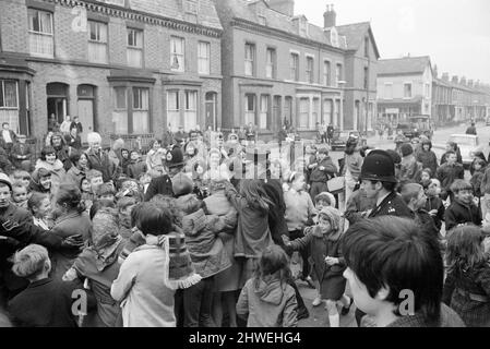 Der Komiker Ken Dodd eröffnet Wohnungen in der Ducie Street und der Beaconsfield Street, Toxteth, Liverpool. Zwei Häuser, eines in jeder Straße, wurden unter einem Team von Schutzhütten- und Planungsexperten zu Wohnungen umgebaut. Die Polizei bündelt Ken zu einem Jeep, nachdem sie ihn vor dem umgebauten Haus in der Beaconsfield Road aus der Menge gerettet hat. 7.. April 1970. Stockfoto