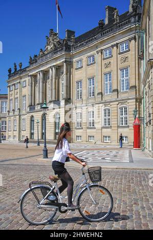 Frau auf dem Fahrrad, Schloss Christians VIII., Königspalast Amalienborg, Königlicher Palastplatz, Kopenhagen (Kobenhavn), Königreich Dänemark Stockfoto