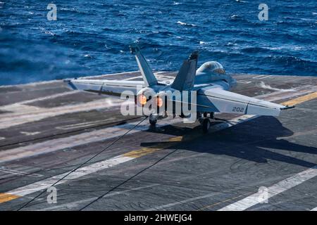 220304-N-XK462-1227 PAZIFISCHER OZEAN (MÄRZ 4, 2022) Kapitän Craig Sicola, Kommandant der USS Nimitz (CVN 68), landet auf dem Flugdeck der Nimitz in einer F/A-18E Super Hornet von den 'Turmfalken' des Strike Fighter Squadron (VFA) 94. Nimitz führt derzeit Routineoperationen durch. (USA Navy Foto von Mass Communication Specialist Seaman Hannah Kantner) Stockfoto