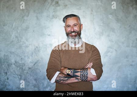 Nicht mit dem Chef vermasseln. Porträt eines selbstbewussten Mannes mittleren Alters, der mit gefalteten Armen vor einem grauen Hintergrund steht. Stockfoto