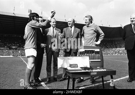 Manchester United 2-0 Burnley, Ligaspiel der Division One in Old Trafford, Samstag, 19.. April 1969. Unser Bild Zeigt ... George Best, der europäische Fußballer des Jahres, erhält die Trophäe „Ballon d'Or“ nach dem Spiel im Old Trafford. Ebenfalls abgebildet waren die früheren Gewinner Bobby Charlton (1966), Denis Law (1964) und Sir Matt Busby, scheidender Manager bei Manchester United. Stockfoto