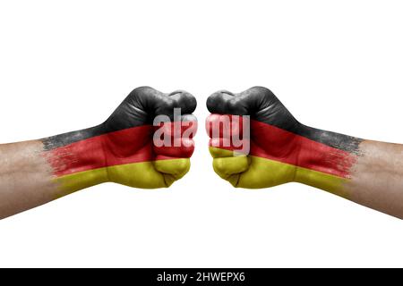 Zwei Hände schlagen sich gegenseitig auf weißem Hintergrund zu. Länderflaggen bemalten Fäuste, Konfliktkrisenkonzept zwischen deutschland und deutschland Stockfoto