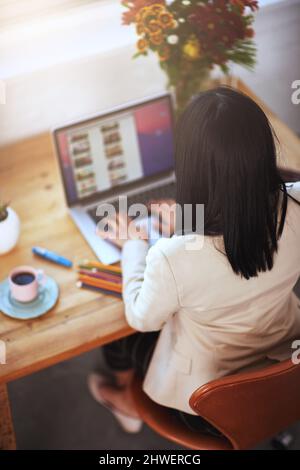 Arbeiten bei der Erweiterung ihres kleinen Unternehmens zu Hause. Aufnahme einer Frau, die in einem Heimbüro an ihrem Laptop arbeitet. Stockfoto
