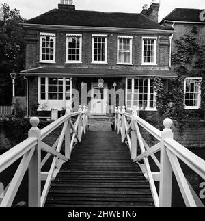 Johnnie und Fanny Cradock, die Kochexpertin im Fernsehen, sind in ein neues Zuhause in der Nähe von Watford, Hertfordshire, gezogen. Das Haus selbst war ursprünglich ein Ferienhaus aus dem 18.. Jahrhundert, das im Laufe der Jahre darauf gebaut wurde, wobei die ursprüngliche Fassade so nahe wie möglich gehalten wurde. Das Interieur wurde komplett von den Cradock's mit allen üblichen modernen Annehmlichkeiten ausgestattet, einschließlich einer großen Küche mit sechs Gasherden, in der sie ein kleines Team von jungen Leuten anweisen, die ihnen bei ihren Fernsehsendungen helfen. 9.. Juni 1969. Stockfoto