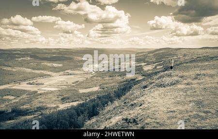 Altes Schwarz-Weiß-Bild von einem touristischen Reisenden und Fotografen macht Bilder von einem schönen Tal Landschaft Panorama Norwegen von Hydalen Hemsedal Stockfoto