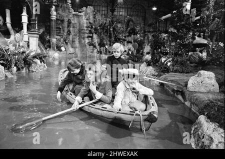 Der Schokoladenraum des Süßigkeitenmachers Willy Wonka mag nicht nur als eines der beeindruckendsten Studiosets, die jemals gebaut wurden, sondern auch als das vielleicht leckerste in die Filmgeschichte eingehen. Die immense Candy Room-Kulisse wurde auf der größten Klangbühne der Bavaria Studios in München errichtet, wo David L. Wolpers Produktion von „Willy Wonka und die Schokoladenfabrik“ nun gedreht wird. Im Boot segeln Denise Nickerson, Peter Ostrum, Julie Dawn und Paris Themmen (dies ist nicht das Boot, das im Film verwendet wird). Sie benutzen riesige Lutscher als Paddel. 8.. Oktober 1970. Stockfoto