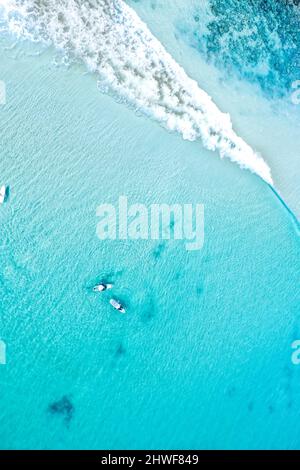 Top Down Luftaufnahme von Surfers auf kristallklarem Wasser Stockfoto