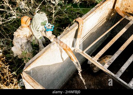Do-it-yourself DIY Garten rustikalen Wasserhahn Füllung der Beton-Reservoir. Die Wasserversorgung wird in der UdSSR/Russland in großem Umfang auf dem Land genutzt Stockfoto