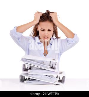 AARGH wird das alles nie durchstehen. Frustrierte Geschäftsfrau mit einem Stapel von Dateien vor sich – isoliert auf Weiß. Stockfoto