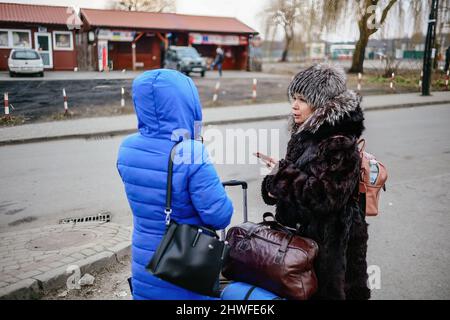 Medyka, Karpatenland, Polen. 3. März 2022. Frauen, die vor dem Krieg fliehen, sprechen mit ihren Angehörigen über eine Freisprecheinrichtung.Polnisch-ukrainischer Grenzübergang in Medyka. Seit Beginn der russischen Invasion in der Ukraine sind rund 700.000 Menschen nach Polen geflohen, um dem Krieg zu entkommen. Trotz erheblicher Fehlinformationen und isolierter Vorfälle werden ukrainische Flüchtlinge mit Empathie, Hilfe und Verständnis begrüßt, aber viele humanitäre Experten deuten darauf hin, dass bei einem so großen Zustrom von Menschen in wenigen Wochen eine Krise eintreten könnte. (Bild: © Filip Radwanski/SOPA Images via ZUMA Press Wire) Stockfoto