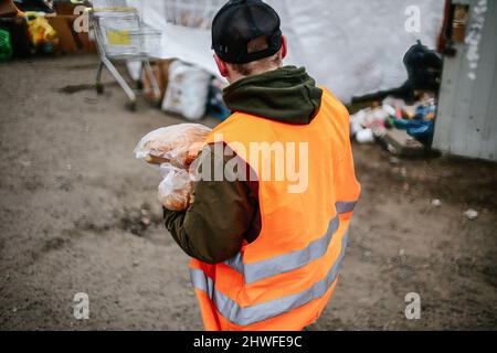Medyka, Karpatenland, Polen. 3. März 2022. Ein Freiwilliger trägt Brot für die Flüchtlinge im Grenzgebiet.Polnisch-ukrainischer Grenzübergang in Medyka. Seit Beginn der russischen Invasion in der Ukraine sind rund 700.000 Menschen nach Polen geflohen, um dem Krieg zu entkommen. Trotz erheblicher Fehlinformationen und isolierter Vorfälle werden ukrainische Flüchtlinge mit Empathie, Hilfe und Verständnis begrüßt, aber viele humanitäre Experten deuten darauf hin, dass bei einem so großen Zustrom von Menschen in wenigen Wochen eine Krise eintreten könnte. (Bild: © Filip Radwanski/SOPA Images via ZUMA Press Wire) Stockfoto