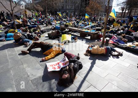 Seattle, Washington, USA. 5.. März 2022. Anhänger inszenieren eine düsteren, als während einer Kundgebung und eines marsches gegen die russische Invasion in der Ukraine eine Sirene eines Luftangriffs im Rathaus von Seattle ertönen wird. Hunderte nahmen an der Veranstaltung „Ukrainischer Marsch und Kundgebung in Seattle gegen den russischen Krieg“ Teil, die von der Ukrainischen Vereinigung des Staates Washington organisiert wurde. Quelle: Paul Christian Gordon/Alamy Live News Stockfoto