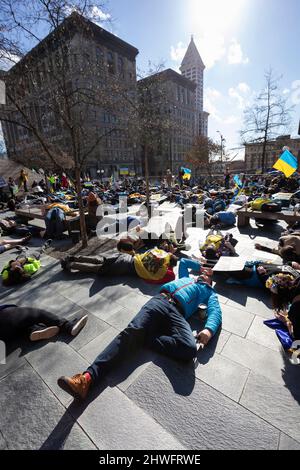 Seattle, Washington, USA. 5.. März 2022. Anhänger inszenieren eine düsteren, als während einer Kundgebung und eines marsches gegen die russische Invasion in der Ukraine eine Sirene eines Luftangriffs im Rathaus von Seattle ertönen wird. Hunderte nahmen an der Veranstaltung „Ukrainischer Marsch und Kundgebung in Seattle gegen den russischen Krieg“ Teil, die von der Ukrainischen Vereinigung des Staates Washington organisiert wurde. Quelle: Paul Christian Gordon/Alamy Live News Stockfoto