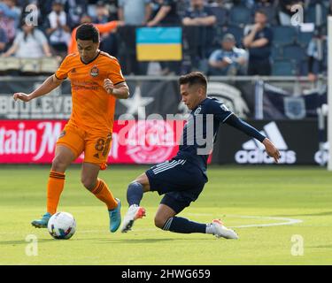 Kansas City, Kansas, USA. 4. März 2022. Der sportliche KC-Mittelfeldspieler Felfelam Hernandez #21 (r) rutscht in einem Tackle gegen den Houston Dynamo-Mittelfeldspieler Memo Rodriguez #8 (l) in der ersten Hälfte des Spiels. (Bild: © Serena S.Y. Hsu/ZUMA-Pressdraht) Stockfoto