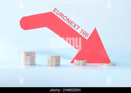 Euronext 100 Index in rotem Abwärtspfeil mit abnehmenden Münzstapel. Pessimistische Kursentwicklung am europäischen Aktienmarkt. Stockfoto