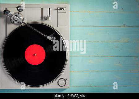 Altes Grammophon mit Vinylplatte auf rustikalem Holztisch, Draufsicht. Stockfoto