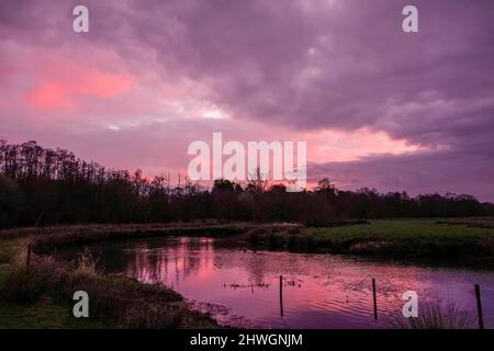 Waverley Lane, Elstead. 06.. März 2022. Ein kalter, aber trockener Start in den Tag für die Heimatkreise. Sonnenaufgang über dem Fluss Wey bei Thundry Meadows in Elstead, in der Nähe von Godalming, in Surrey. Kredit: james jagger/Alamy Live Nachrichten Stockfoto