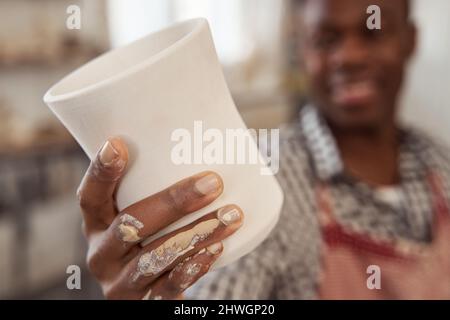 Keramiker zeigt sein Töpferstück vor der Kamera Stockfoto