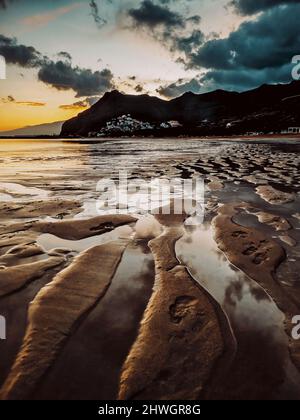 Grundansicht der erstaunlichen Strandlandschaft mit Sand und Meerwasser und tollen Farben beim Sonnenuntergang im Hintergrund. Konzept der Natur und Sommerurlaub desti Stockfoto