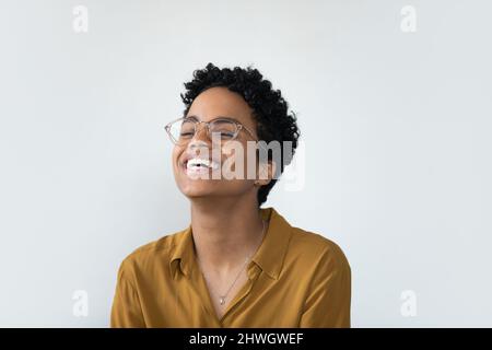 Fröhliche junge afrikanische Geschäftsfrau in lässiger, stilvoller Brille Stockfoto