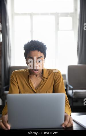 Überrascht schockiert Millennial Black Mädchen Blick auf Computer-Display Stockfoto