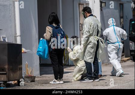 Familienmitglieder führen Trauerrituale außerhalb der öffentlichen Leichenhalle von Victoria durch. Mit dem jüngsten Anstieg der Todesfälle aufgrund des Omicron-Ausbruchs in Hongkong sind die örtlichen Leichenhallen in der Lage, und die Regierung verlässt sich auf Krankenhäuser und private Leichenhäuser, um Hilfe zu erhalten. Am 5. März 2022 sind in der letzten Welle 1561 Menschen gestorben, was die Gesamtzahl der bekannten COVID-19-Todesfälle in Hongkong auf 1774 brachte. Die meisten Todesfälle wurden bei älteren Menschen verzeichnet, von denen viele entweder nicht oder nicht vollständig geimpft waren. (Foto von Ben Marans/SOPA Images/Sipa USA) Stockfoto